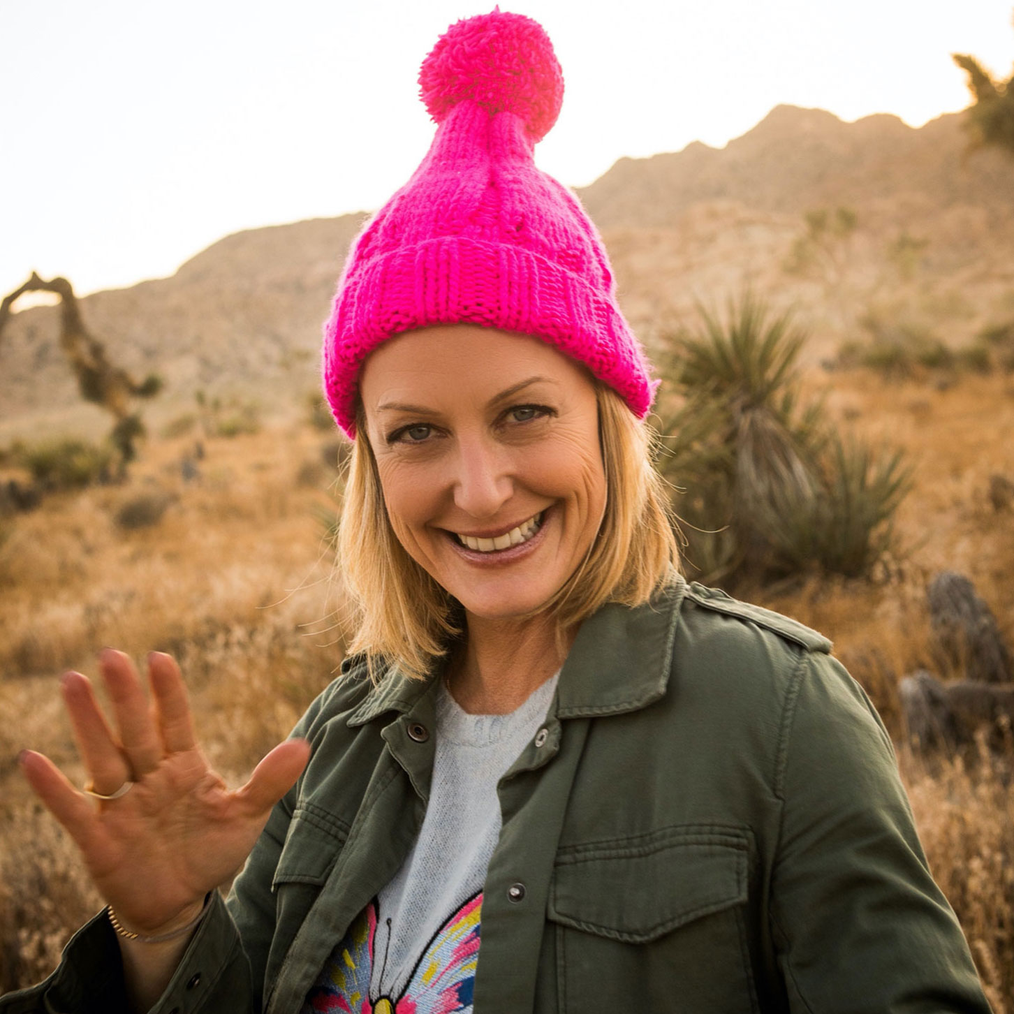 Elizabeth waves wearing a pink hat