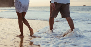 couple walking on the beach in the surf