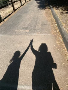 shadow of hands together while walking