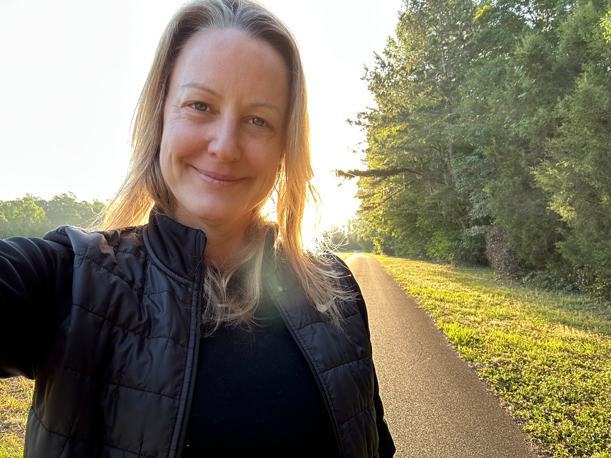 Elizabeth Winkler taking photo of herself on a sunny path