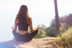 woman sitting in a field meditating