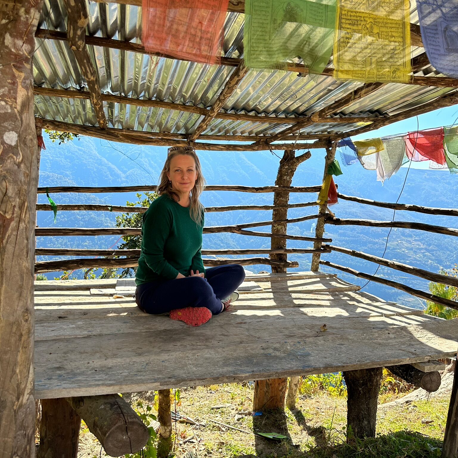 Elizabeth Winkler sitting cross legged in a hut in Bhutan